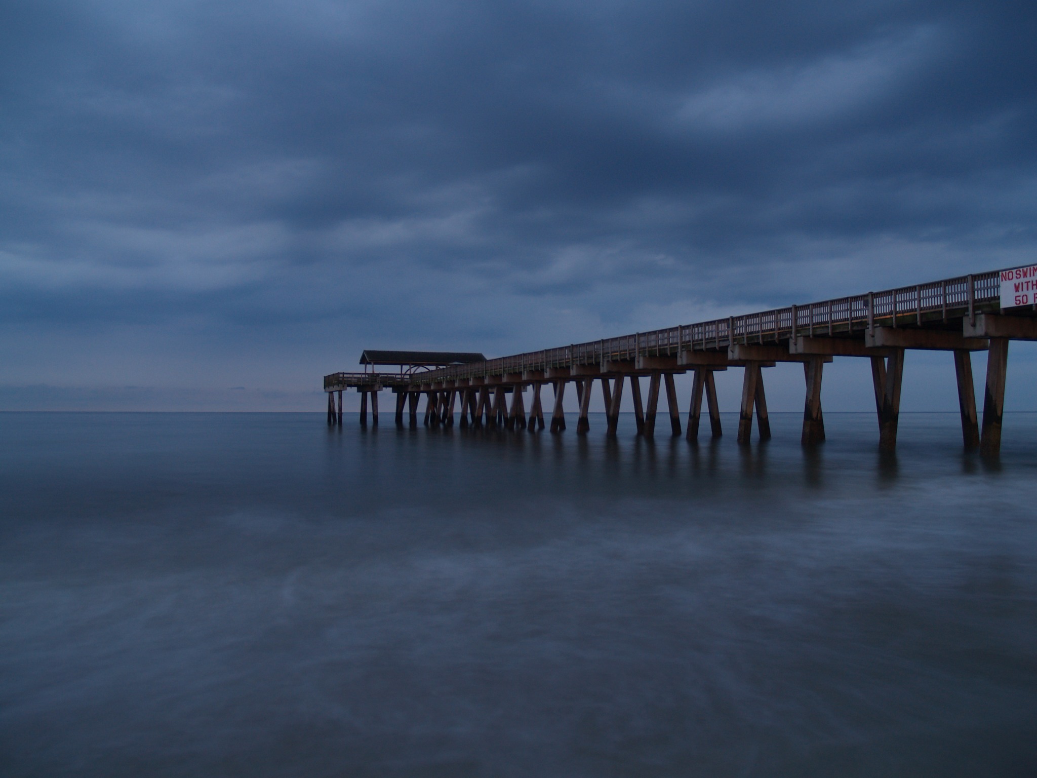 Pier reaching into the water at blue hour